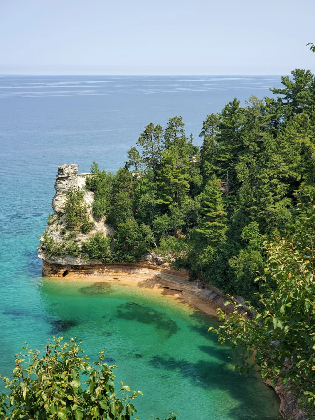 Strikingly colored, oxidized sandstone cliffs towering over the clear waters of Pictured Rocks National Lakeshore