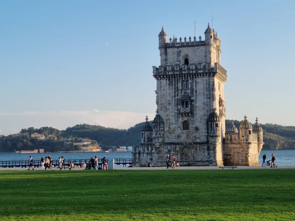 Belém Tower standing isolated in the water against a clear sky