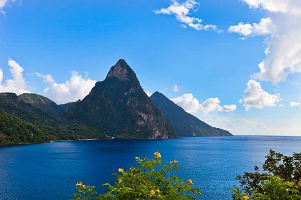 Lush green slopes of Gros Piton rising dramatically from the turquoise sea in Saint Lucia