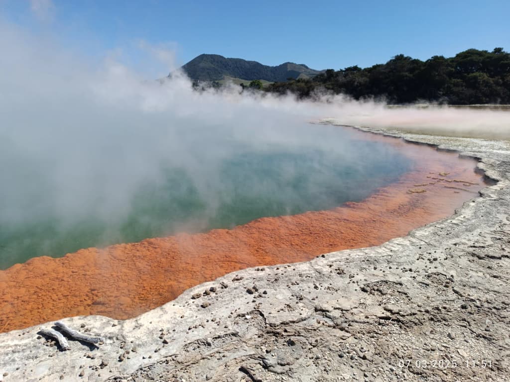Thick white steam rising from the bright orange and green edges of the Champagne Pool at Waiotapu Thermal Wonderland