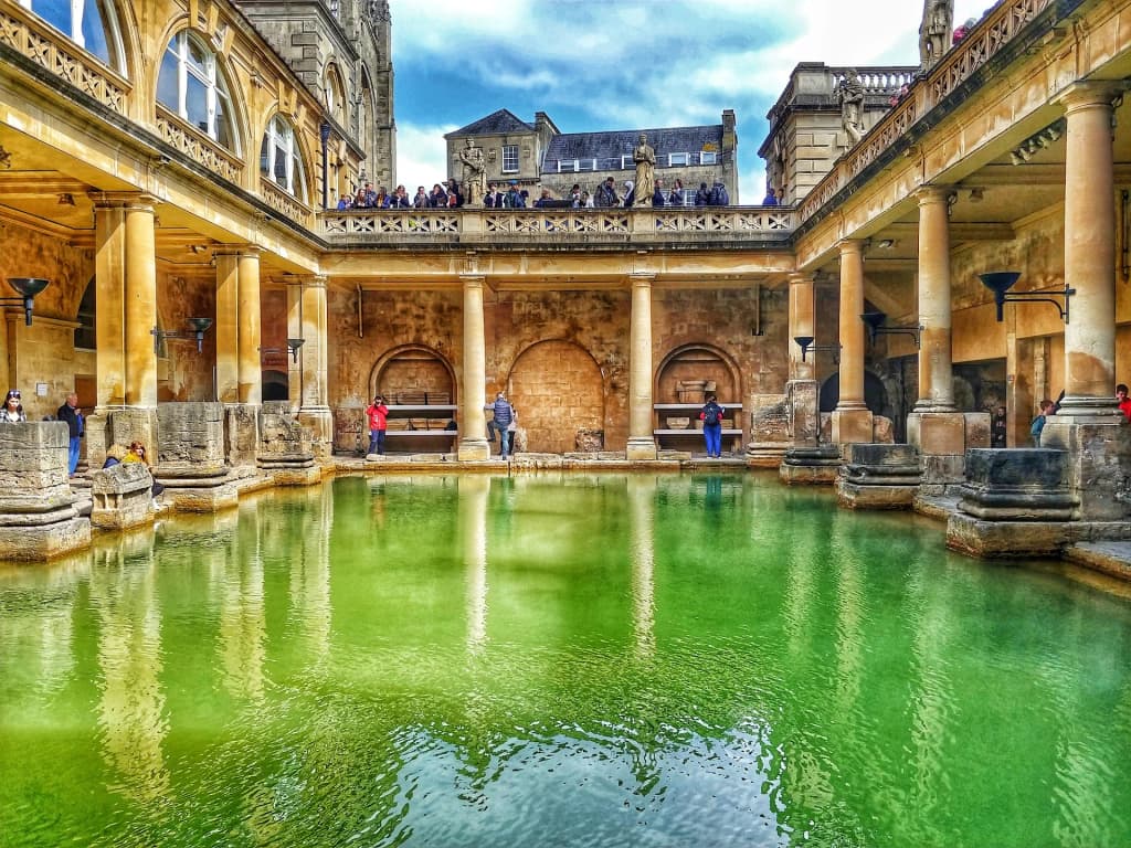 Steam rising from the emerald waters of the ancient Roman Baths in Bath, England