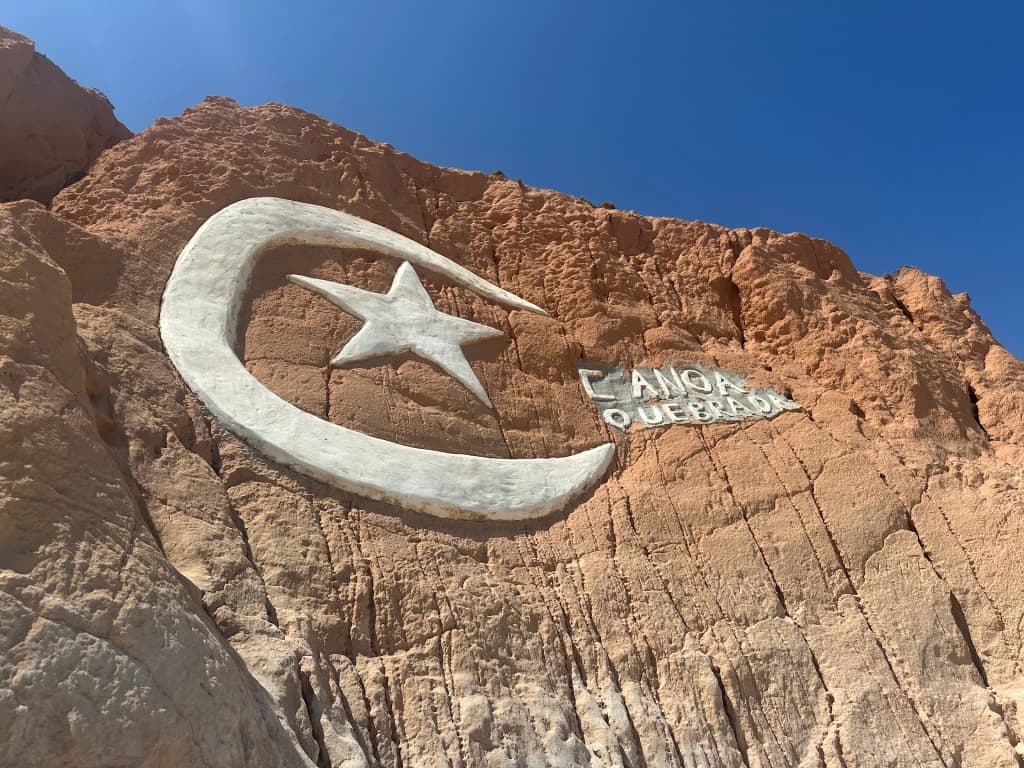 The iconic Canoa Quebrada moon and star symbol carved into the cliff