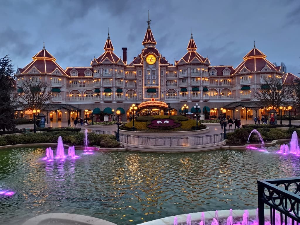 The grand entrance of Disneyland Paris against a bright sky