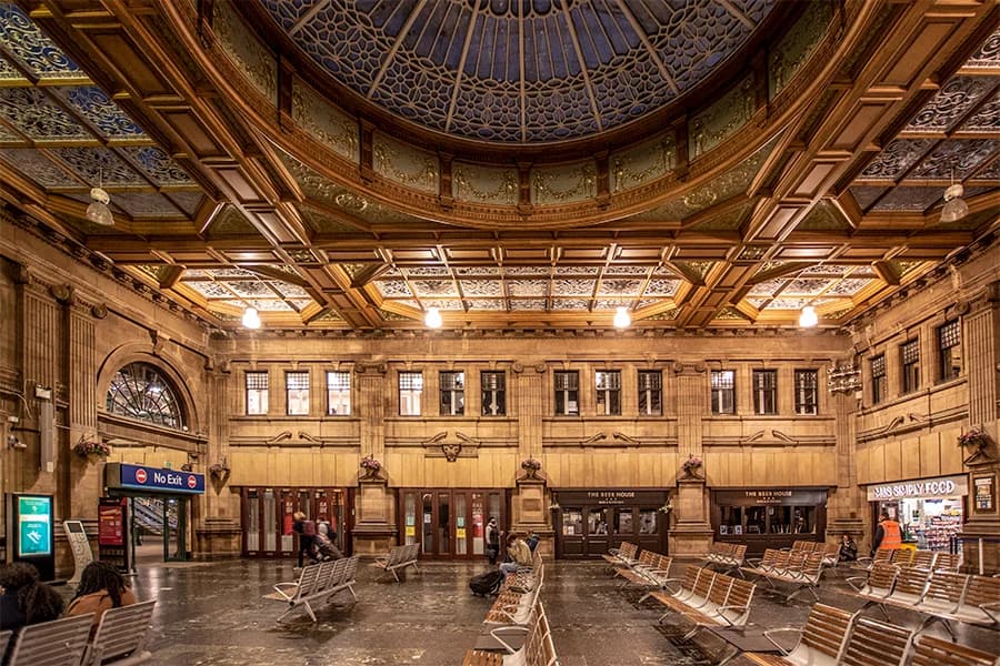 The expansive glass roof and bustling platforms of Edinburgh Waverley station