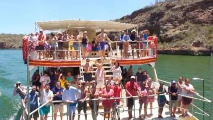 Catamarán navegando entre los altos acantilados naranjas de los Cañones de Xingó