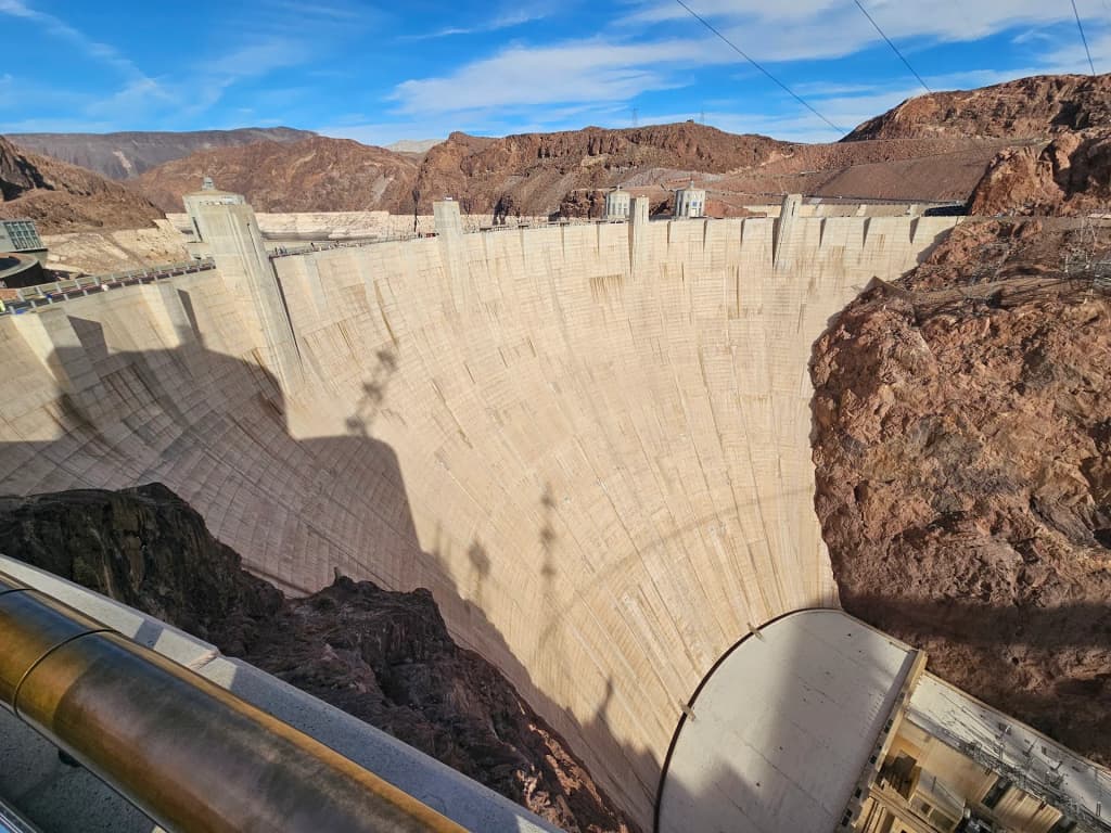 Massive concrete walls of the Hoover Dam towering over the Colorado River