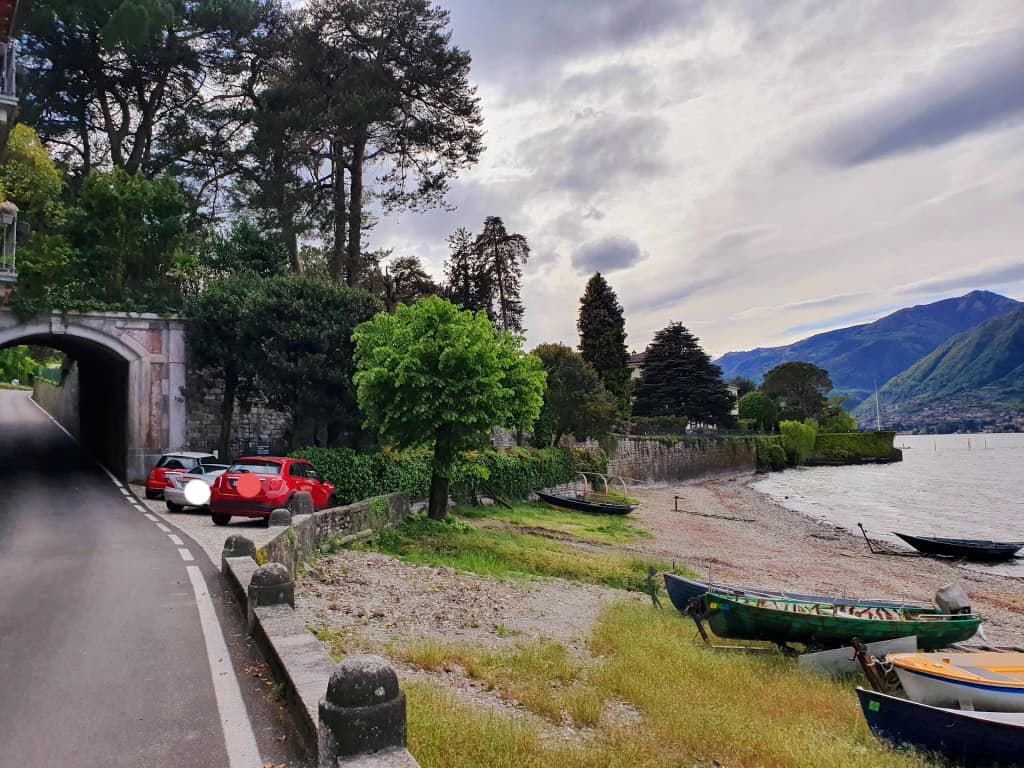 A picturesque view of Bellagio architecture with lush green plants framing the cobblestone path