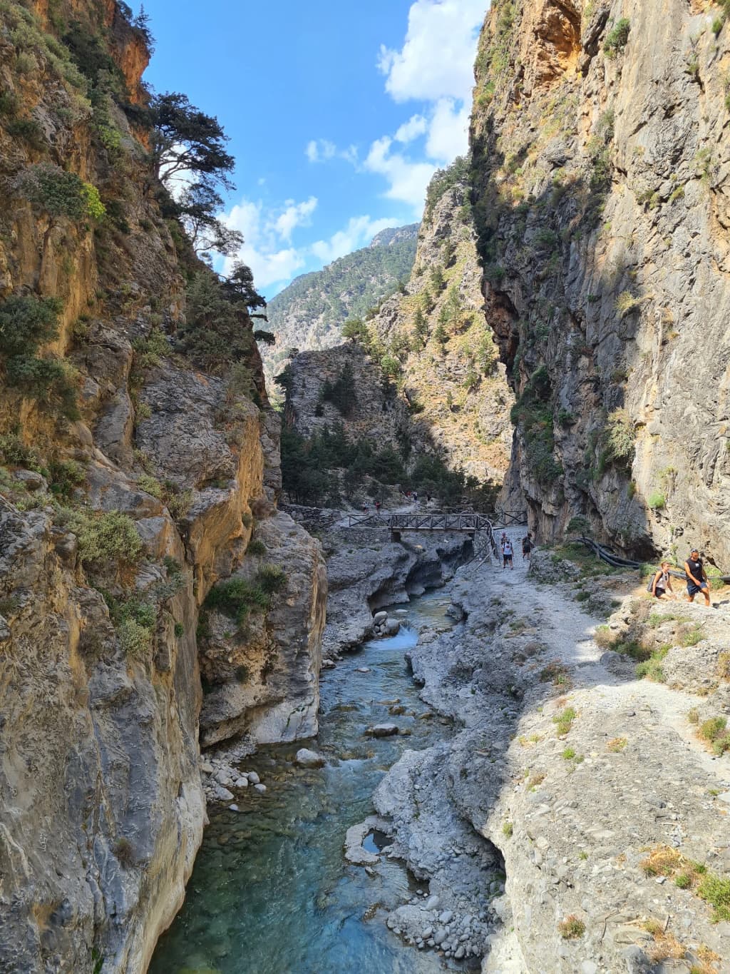 Towering rock walls closing in on the hiking trail through the dramatic Samaria Gorge