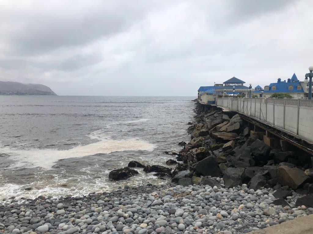 Surfers catching morning waves at Playa Waikiki in Lima