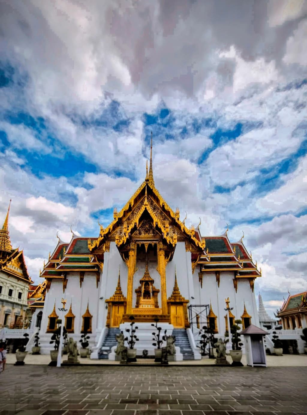 Tourists walking through the majestic grounds of The Grand Palace in Bangkok