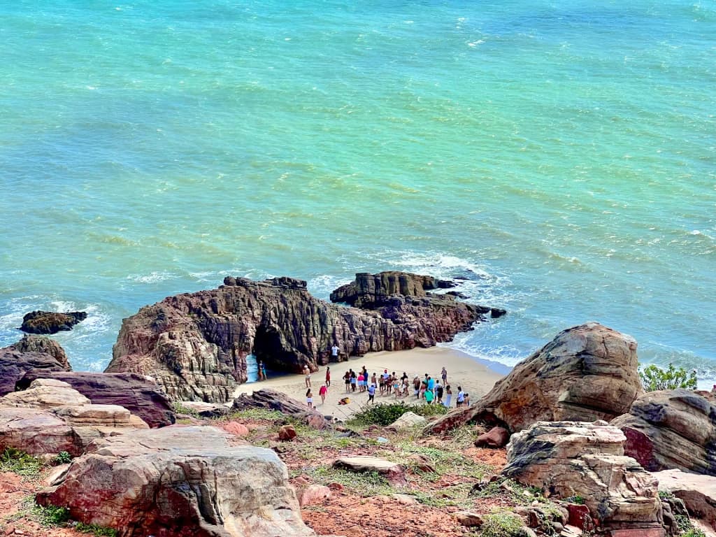 The iconic rock formation of Pedra Furada standing against the crashing waves