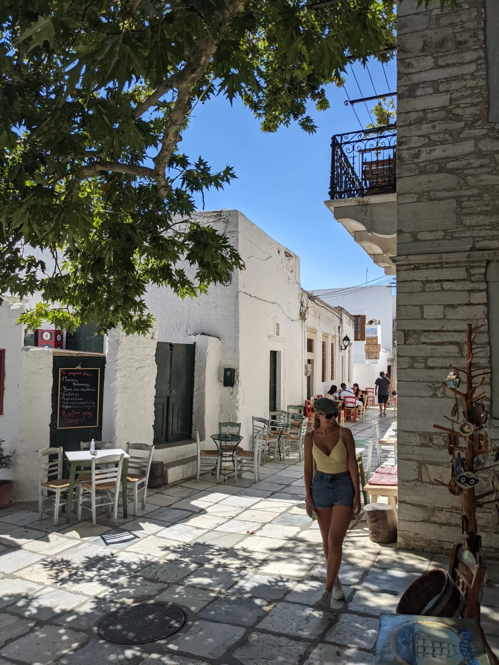 A quiet, sun-drenched street in Naxos where whitewashed walls meet the deep blue Aegean sky