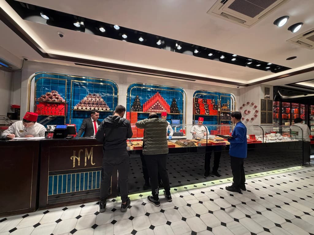 A ferry cuts through the deep blue waters of the Bosphorus Strait under a golden Istanbul sky