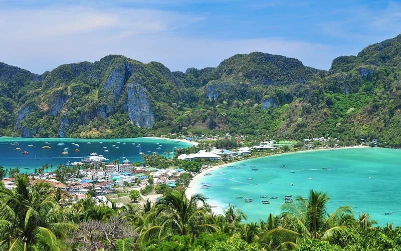 Longtail boats floating in the crystal clear waters of Phi Phi Islands, Thailand