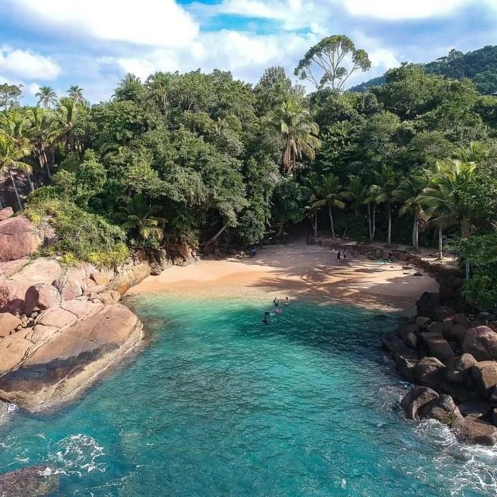 Aguas turquesas de Praia do Português entre acantilados