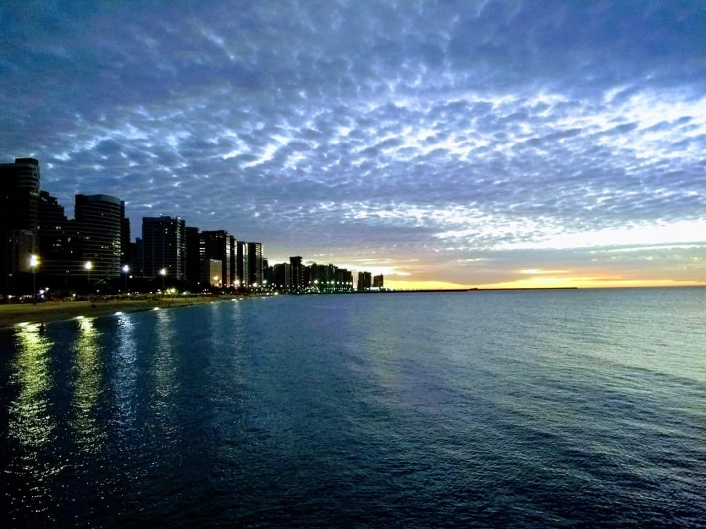 Praia de Iracema’s golden morning, with locals and visitors mingling on the sand