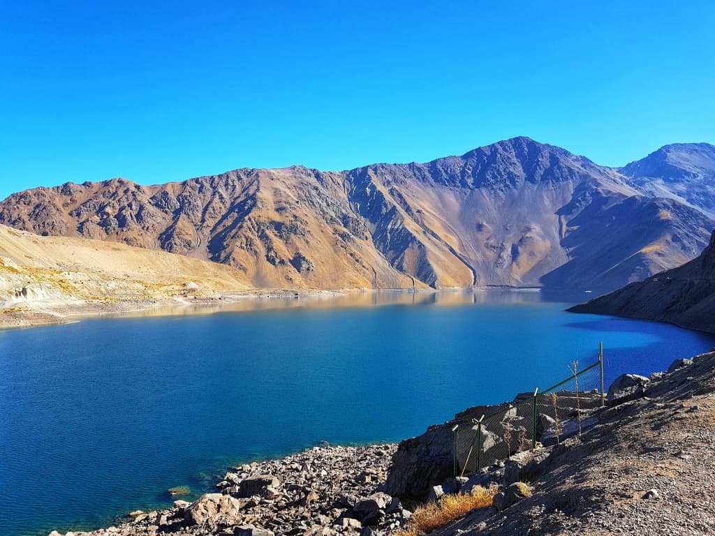 The rugged, snow-dusted peaks of Cajón del Maipo under a brilliant blue sky