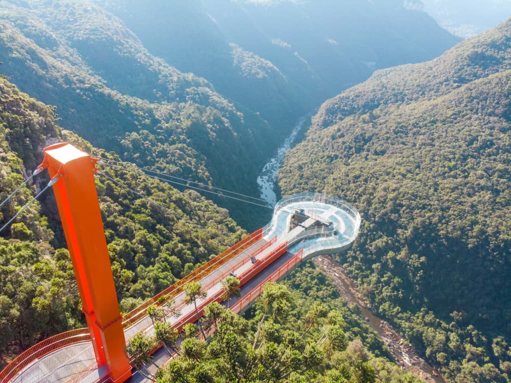 Glass platform extending over the lush green valley at Skyglass Canela