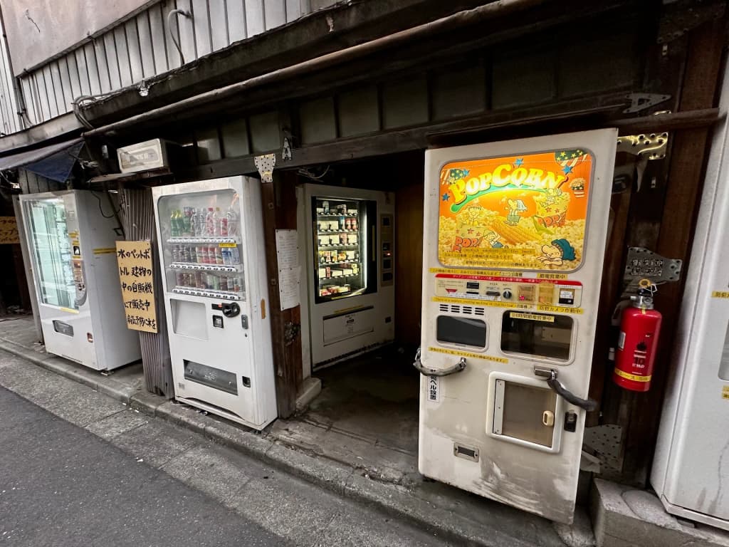 Fileiras de máquinas de venda automáticas coloridas alinhadas em uma rua de Tóquio