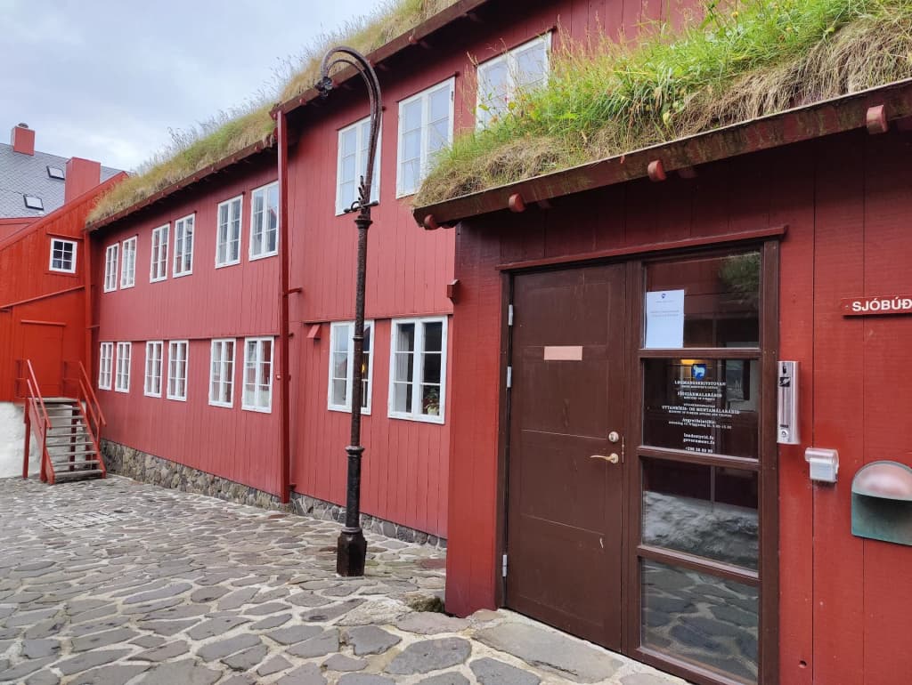 Red wooden buildings with grass roofs at Tinganes in Tórshavn