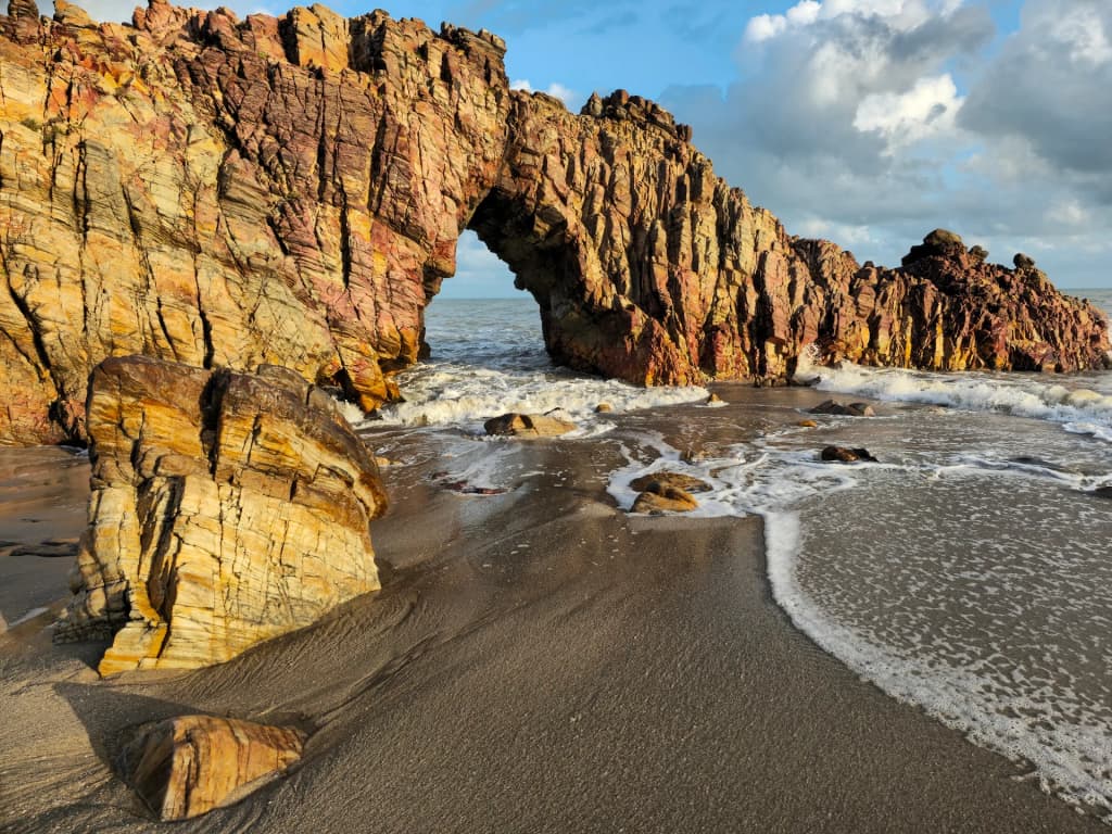 A icônica Pedra Furada diante das ondas do Atlântico