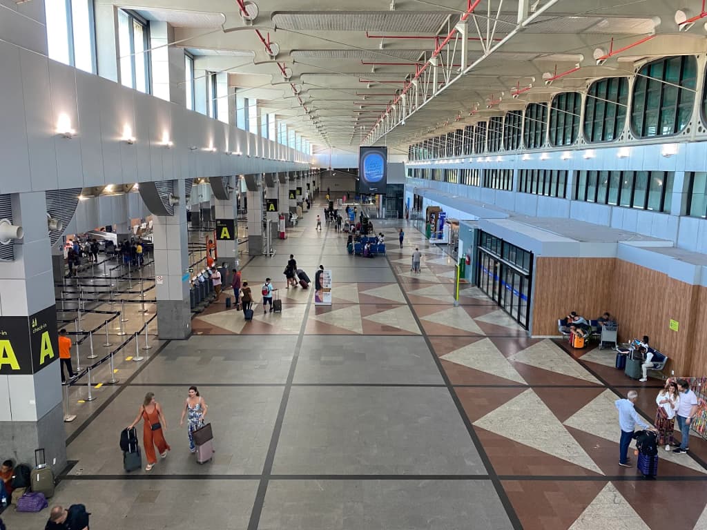 Travelers walking through the bright, modern concourse of Salvador International Airport