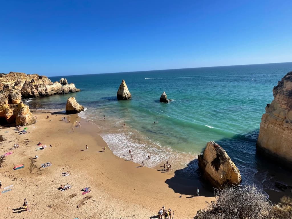 Hidden caves and terracotta rocks at Praia dos Três Irmãos in Portimão