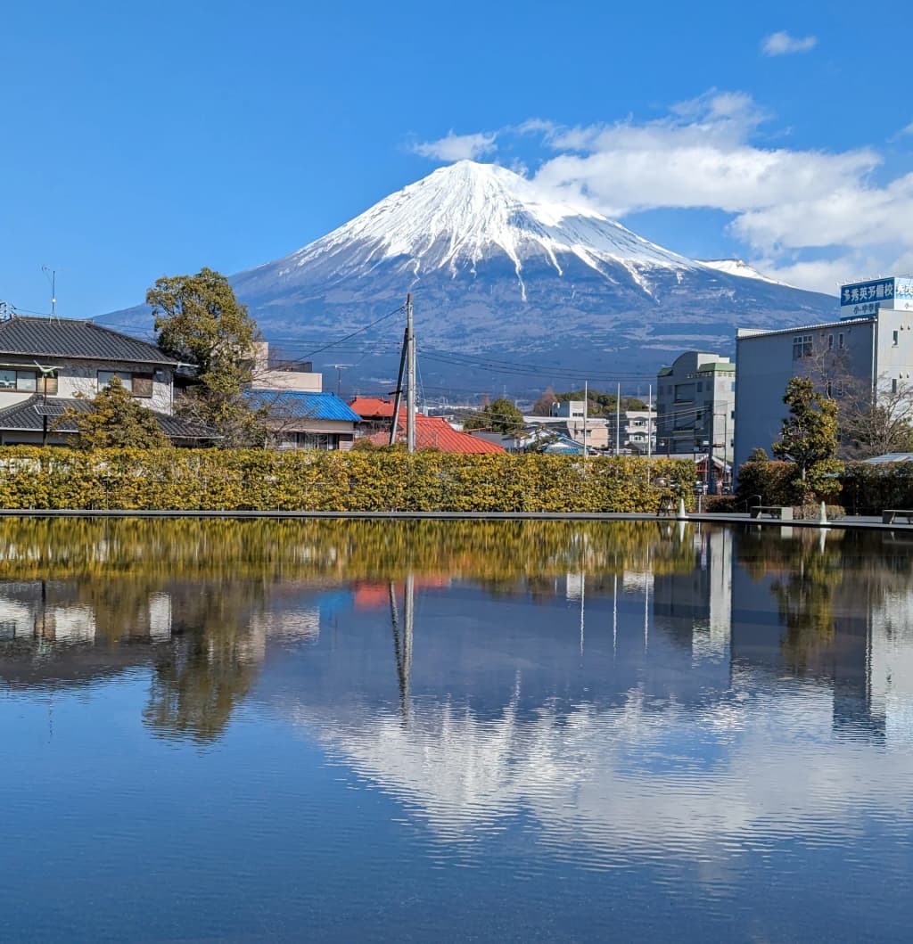 La cima nevada del Monte Fuji emerge entre nubes suaves, vigilante silencioso de Japón