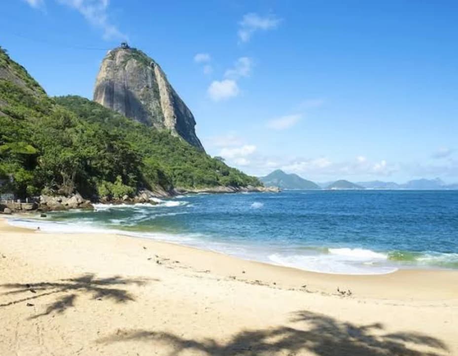 La luz de la mañana ilumina la arena de Praia Vermelha antes de la caminata