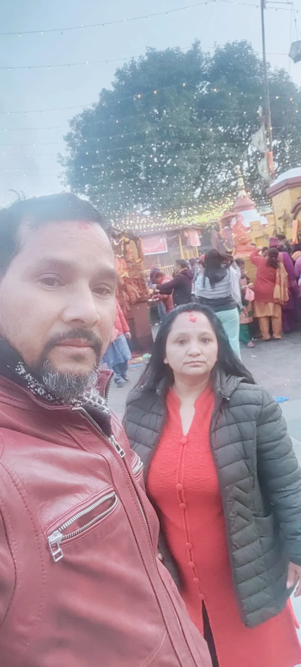 Trekkers crossing a suspension bridge with prayer flags, deep gorge below