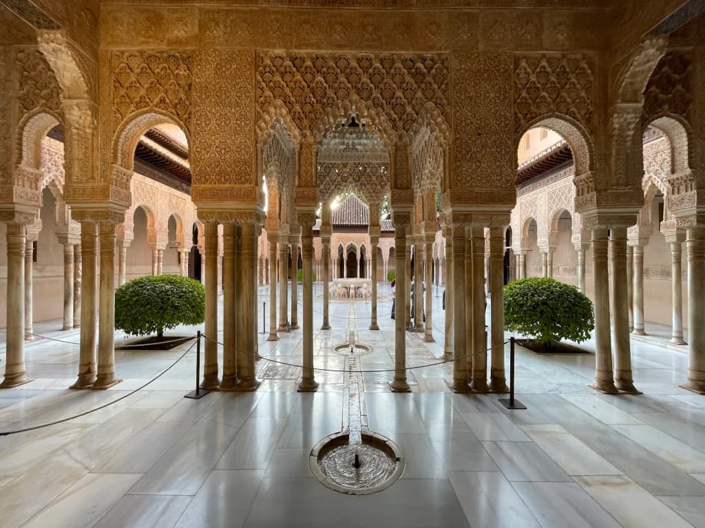 Intricate Islamic arches and gardens inside the Alhambra, Granada