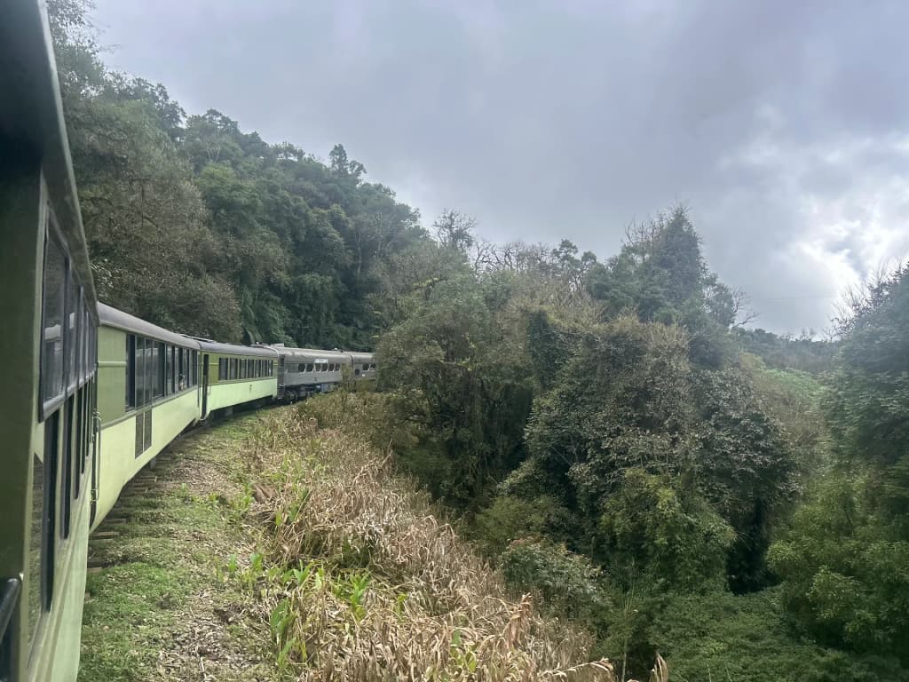 Serra Verde Express train crossing a bridge in the mountains