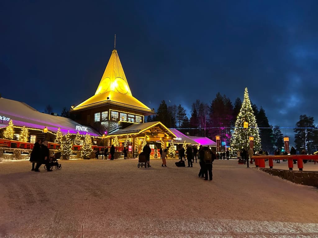 Santa Claus Village blanketed in snow, glowing under the polar night