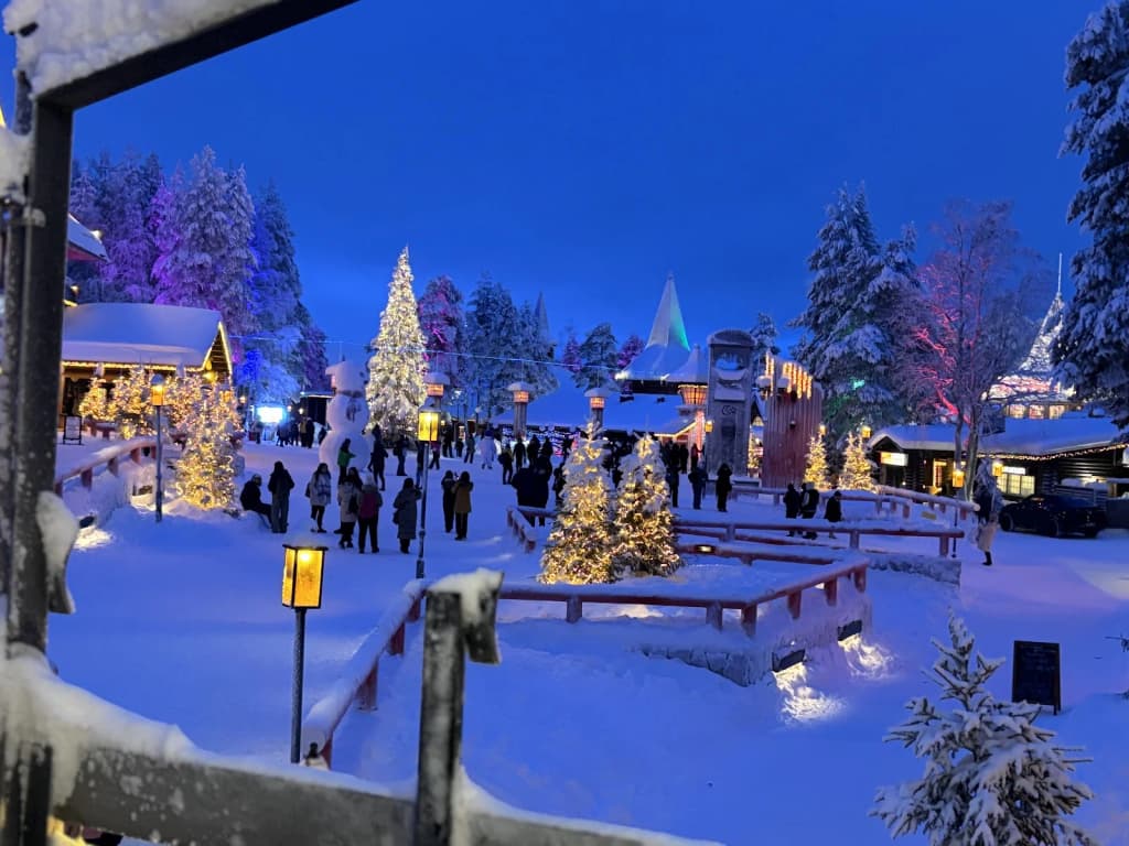 Glass igloo accommodation glowing at night, surrounded by snow