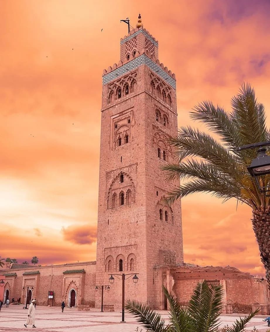 A Mesquita Koutoubia se erguendo sobre a medina de Marrakech ao amanhecer, banhada por luz dourada
