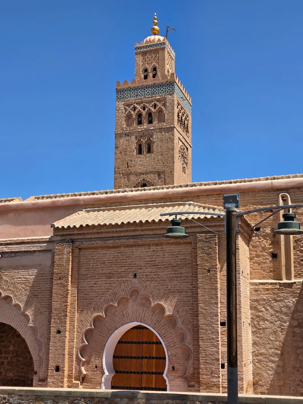 Vista noturna da medina de Marrakech com a Mesquita Koutoubia iluminada, luzes da cidade brilhando