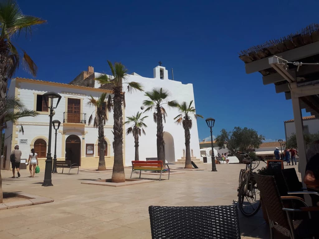 Whitewashed village street with boutiques and flowers in Formentera