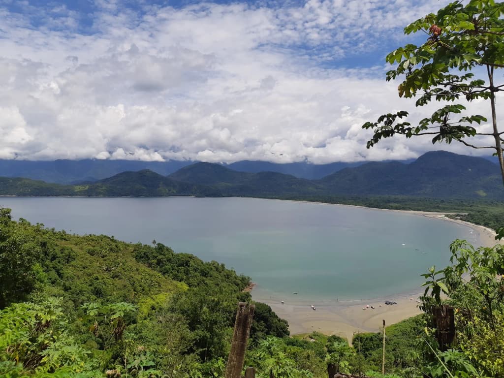 Luz dorada de la mañana en Praia da Almada, con montañas al fondo y mar en calma