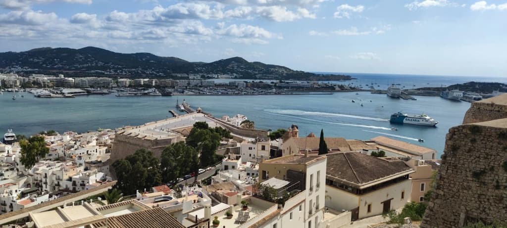 Muros de pedra banhados de sol em Dalt Vila, Ibiza, com o Mediterrâneo ao fundo
