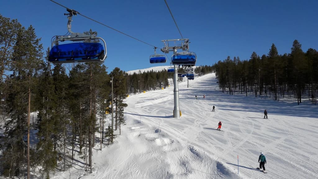 Glass-roofed igloo hotel glowing under the northern lights in Lapland, Finland