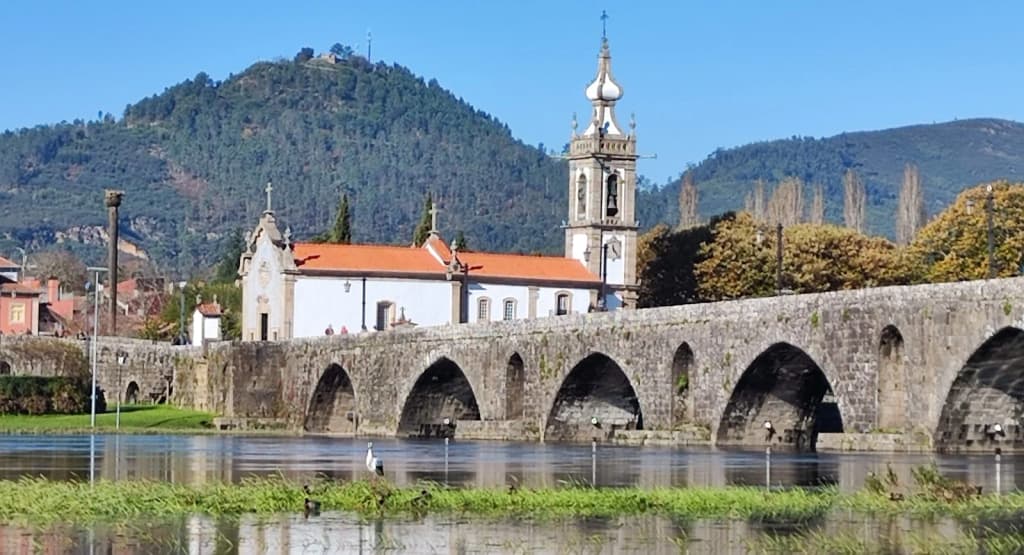 A ponte romana de Ponte de Lima, iluminada pelo sol e cheia de visitantes de domingo