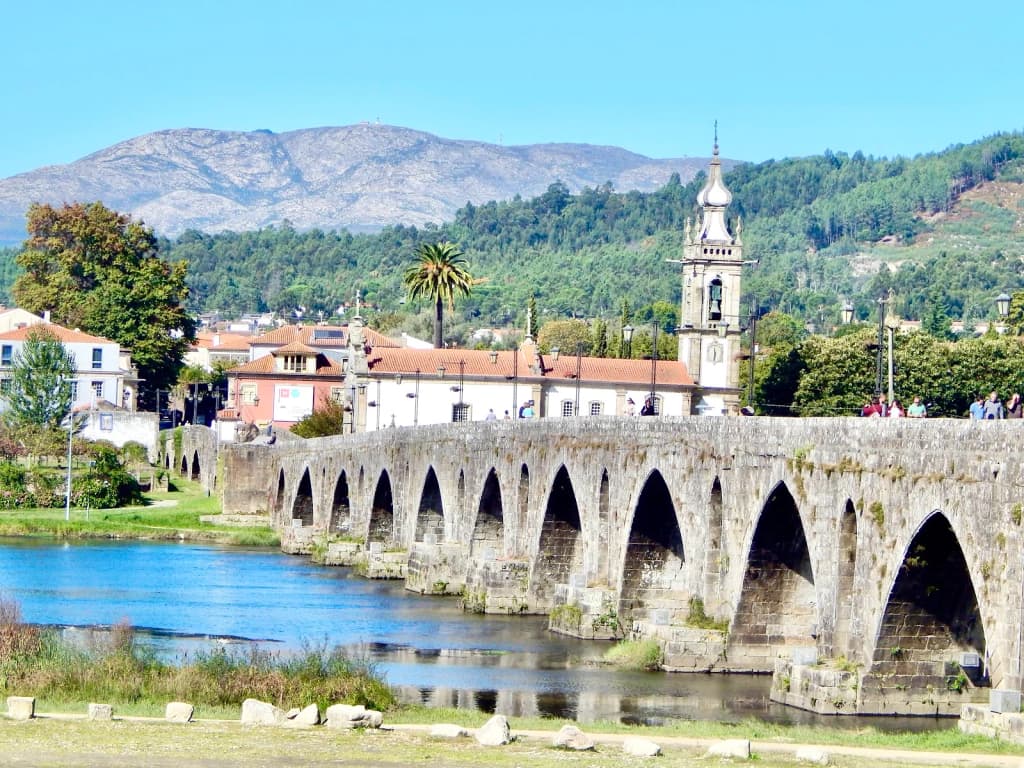 Mesa rústica com vinho verde, arroz de sarrabulho e enchidos locais