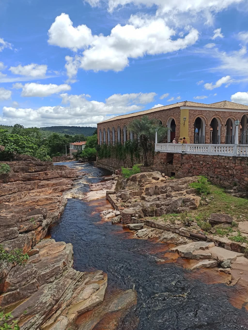 Aventureros nadando en una poza turquesa bajo una cascada en Chapada Diamantina