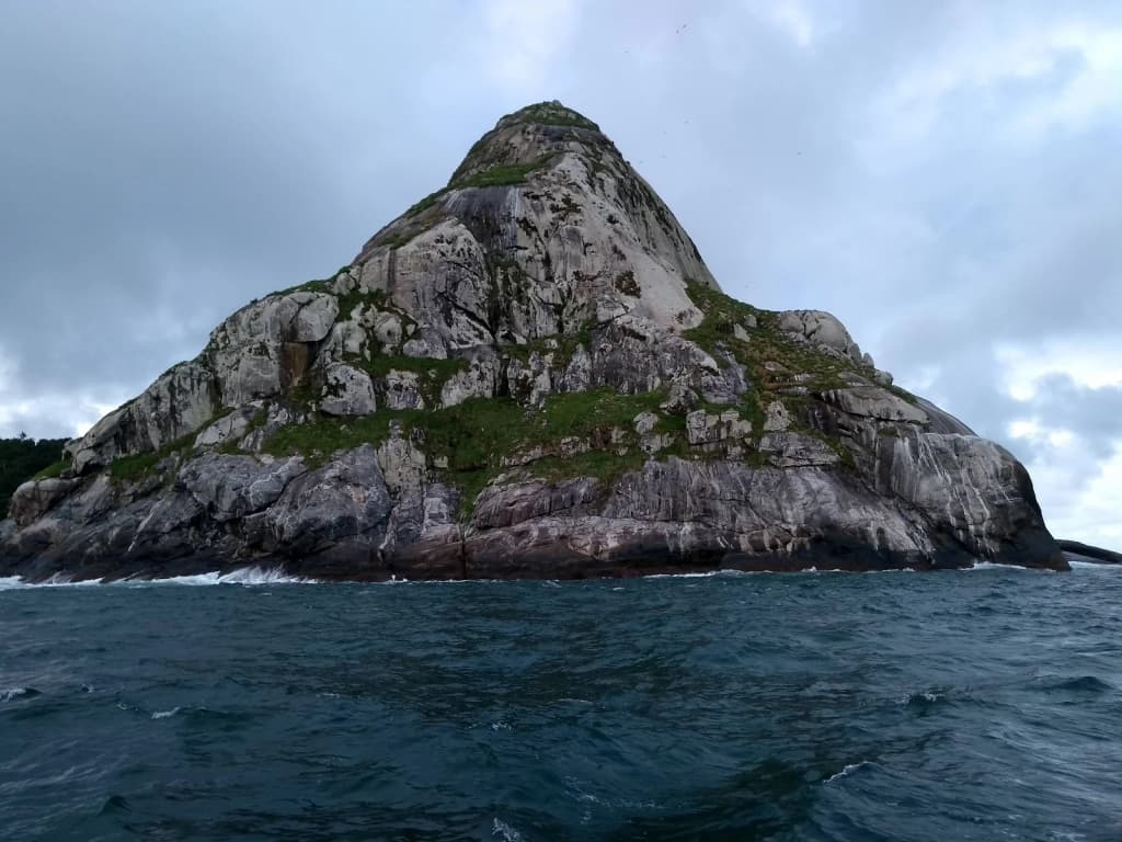Locals and travelers sharing a sunset moment on the beach, silhouettes against a fiery sky