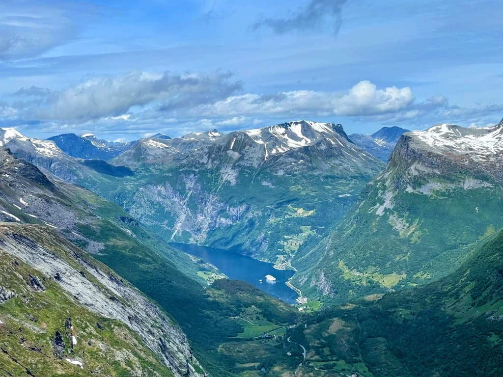 Dramatic view of Trolltunga rock ledge above a lake