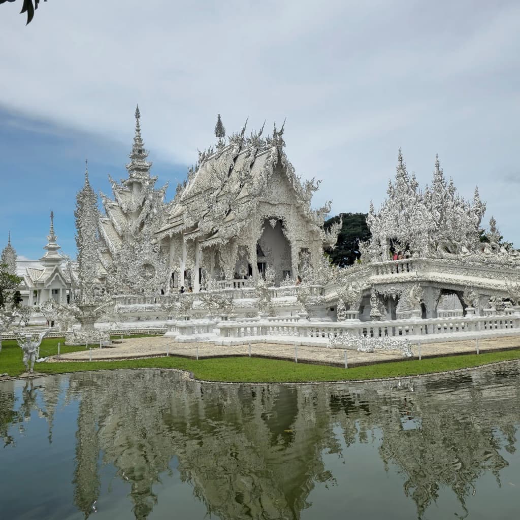La deslumbrante fachada blanca del Wat Rong Khun, el Templo Blanco, brillando al sol