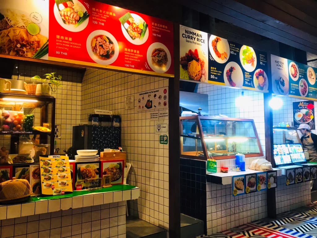 A close-up of hands lighting a paper lantern, faces aglow with anticipation