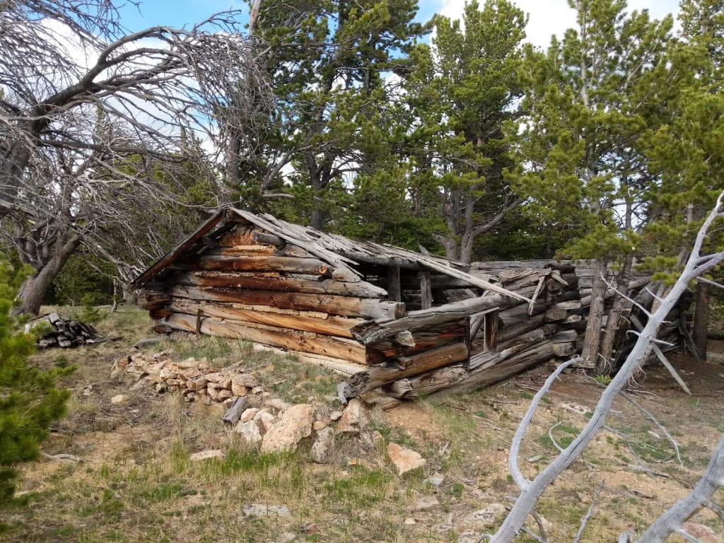 Hiker on a rocky Colorado trail, clouds rolling in