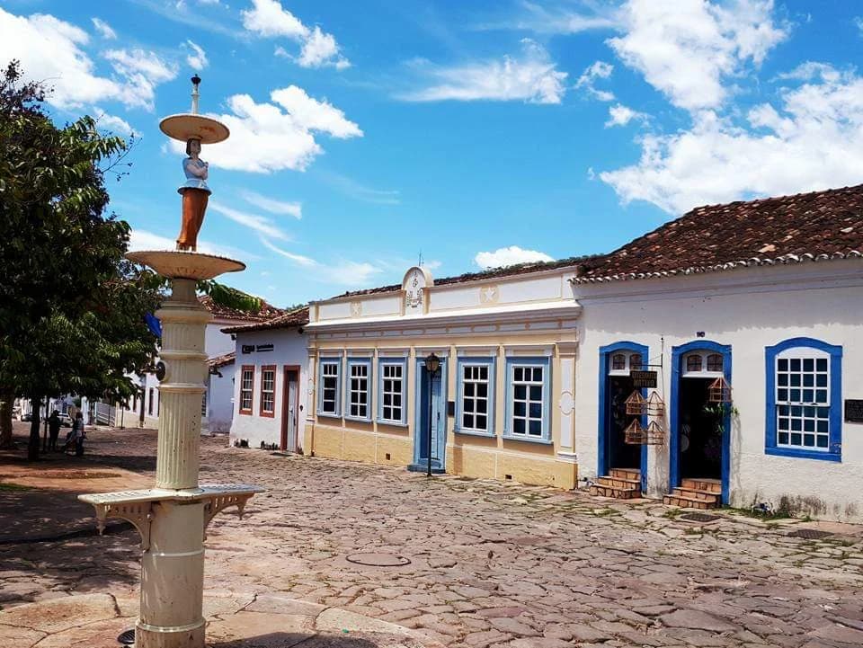 Colorful colonial houses line a cobbled street in the historic center of Goiás, Brazil.