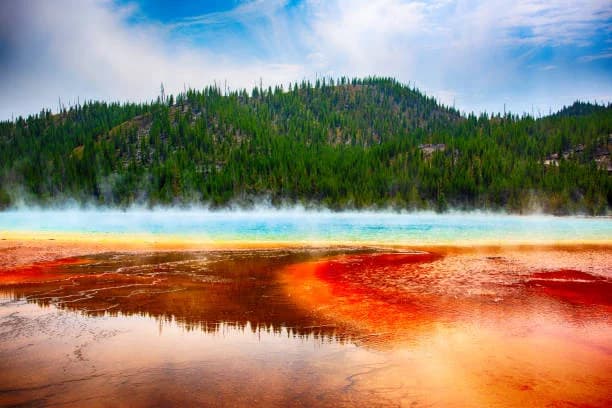 Gêiser de Yellowstone em erupção, vapor e arco-íris
